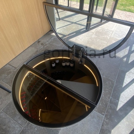 Круглый стеклянный люк с электроприводом и обратной петлей на винтовую лестницу винного погреба - открытая створка